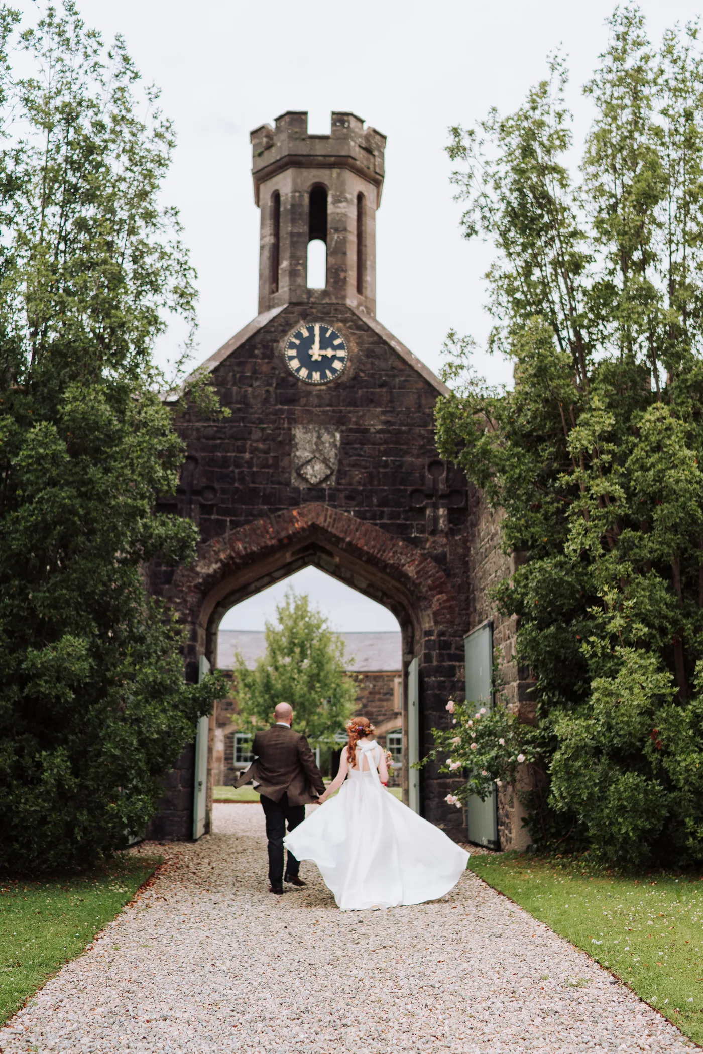 Bride groom walking through arch lissanoure castle